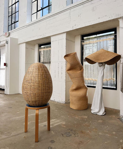 Egg shaped light shade with tall wavy storage basket and lamp shade.