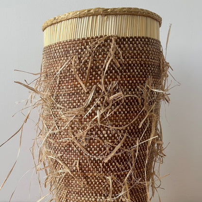 Tall floor standing storage basket, natural colored with a shaggy textured exterior. Made in Ghana from local sustainable materials.