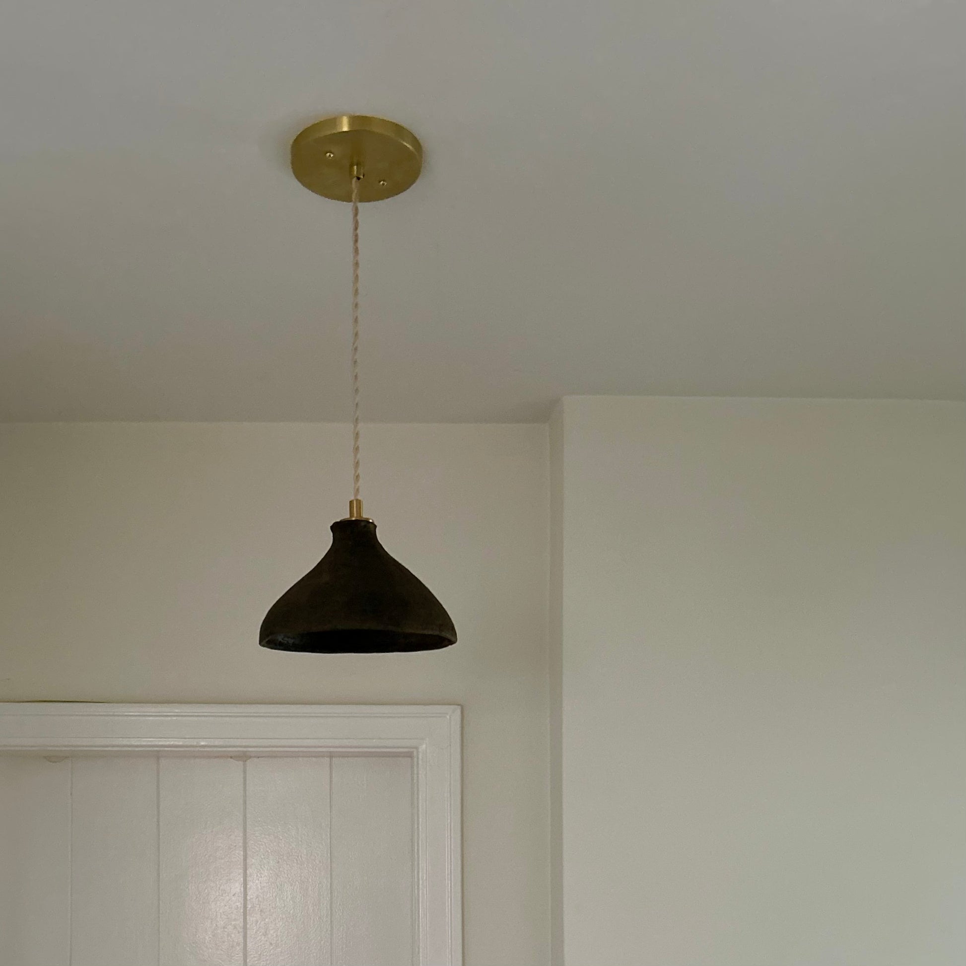 The Mud Pendant lights are a smaller conical shape, handmade in matte black ceramic in Northern Ghana. They work well in kitchens or dining areas.