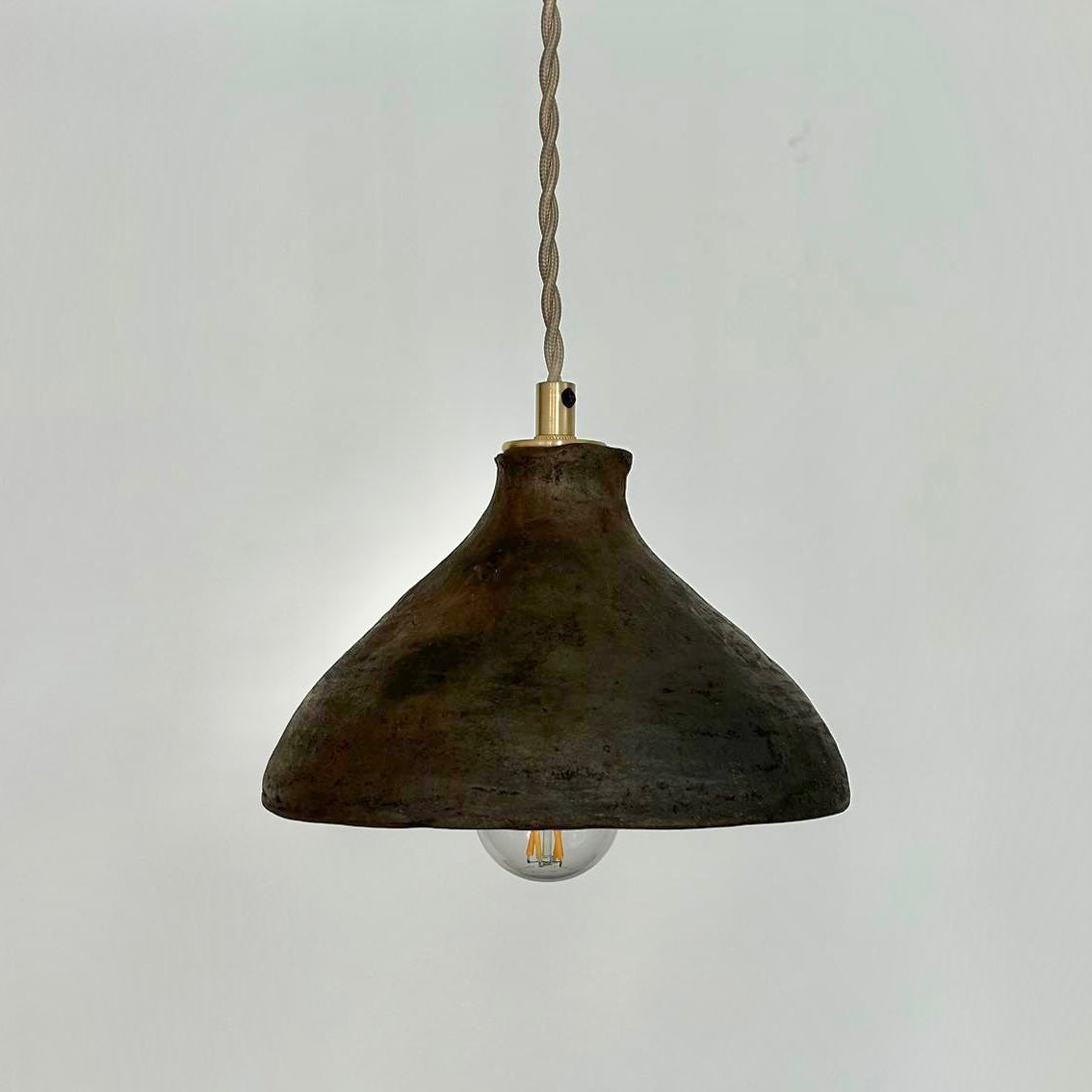 The Mud Pendant lights are a smaller conical shape, handmade in matte black ceramic in Northern Ghana. They work well in kitchens or dining areas.