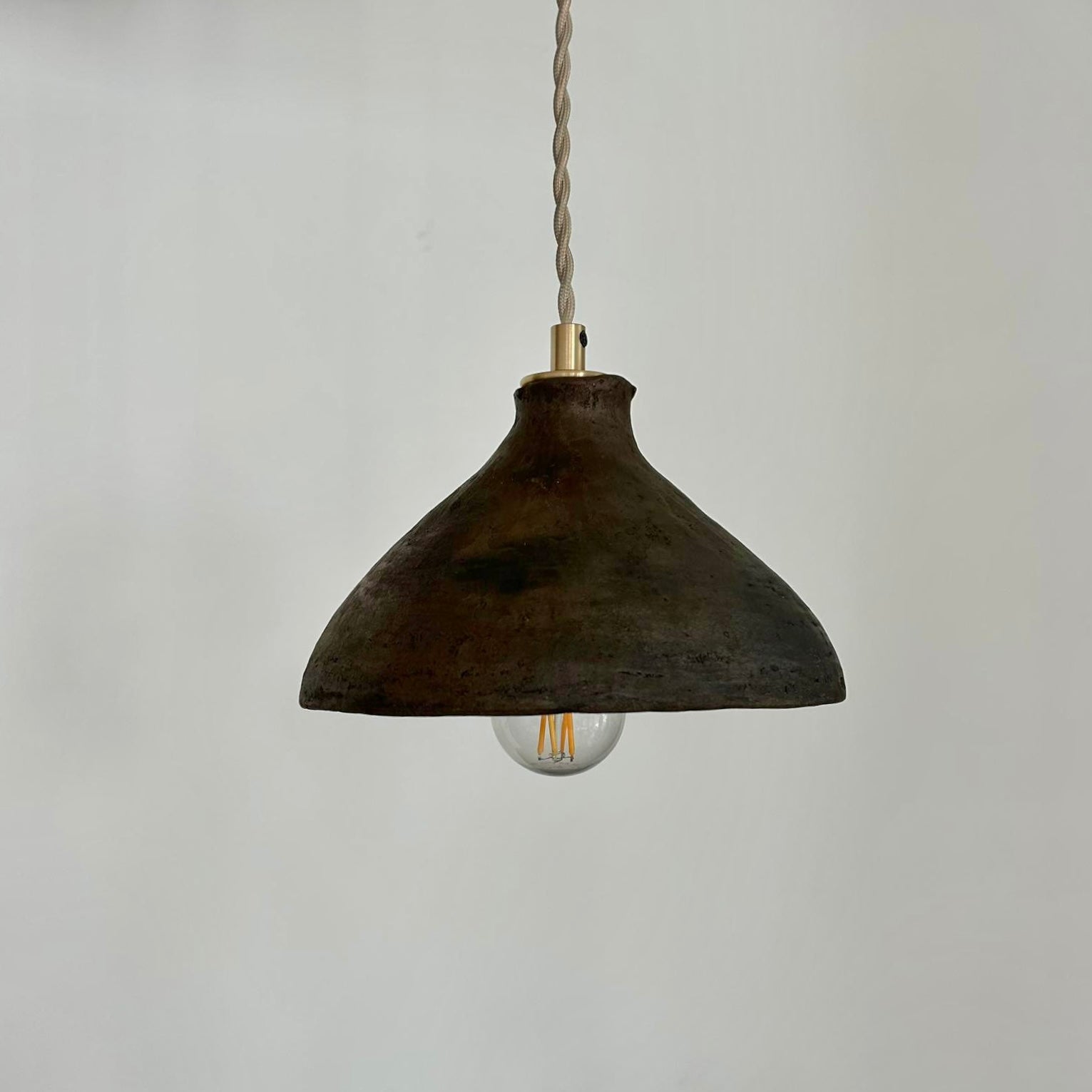 The Mud Pendant lights are a smaller conical shape, handmade in matte black ceramic in Northern Ghana. They work well in kitchens or dining areas.