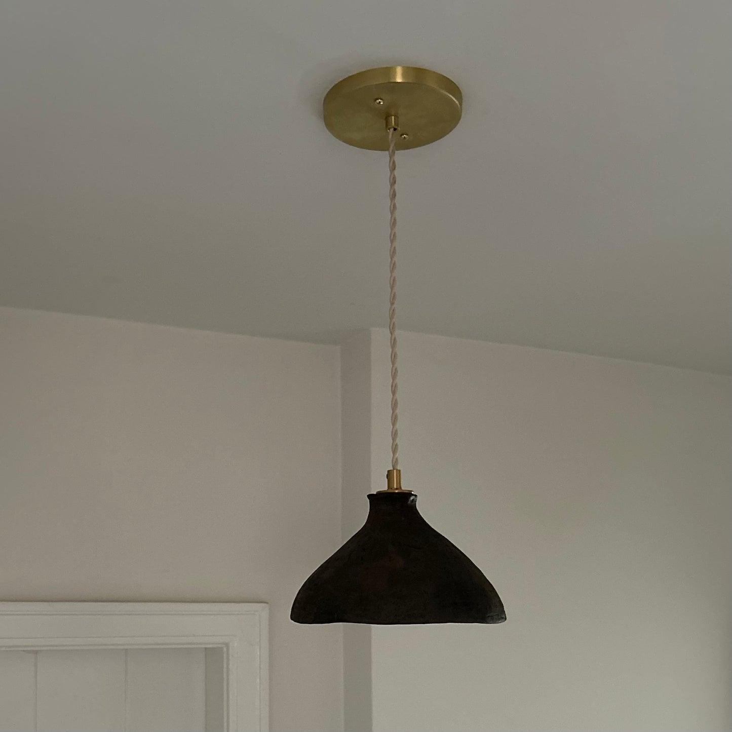 The Mud Pendant lights are a smaller conical shape, handmade in matte black ceramic in Northern Ghana. They work well in kitchens or dining areas.