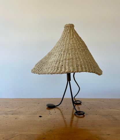 Modernist, iron table lamp from France circa 1950s. Paired with a coned shaped hand woven lamp shade.