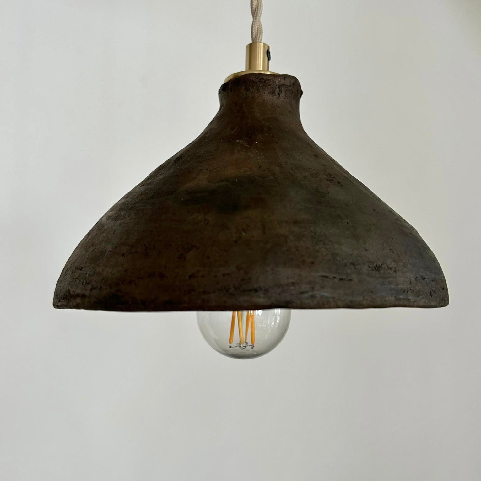 The Mud Pendant lights are a smaller conical shape, handmade in matte black ceramic in Northern Ghana. They work well in kitchens or dining areas.