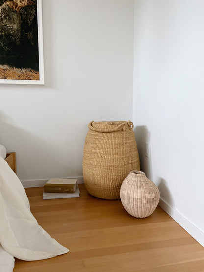 Large pear-shaped handwoven basket, with two handles, with a smaller gourd basket. Made in Ghana from local sustainable grass. 