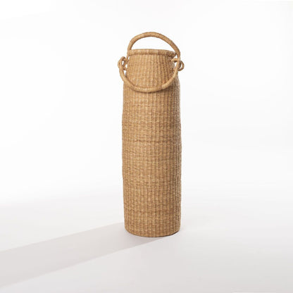 A tall column-shaped basket with two handles. More sculpture than storage, these handwoven baskets are made in Ghana from natural materials.