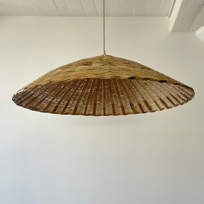 The Toasted Carrizo Pendant Light is a hand-woven, upside-down dish-shaped pendant light, made from a natural colored, bamboo-like river reed by skilled craftspeople in Oaxaca, Mexico.