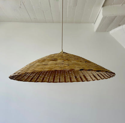 The Toasted Carrizo Pendant Light is a hand-woven, upside-down dish-shaped pendant light, made from a natural colored, bamboo-like river reed by skilled craftspeople in Oaxaca, Mexico.