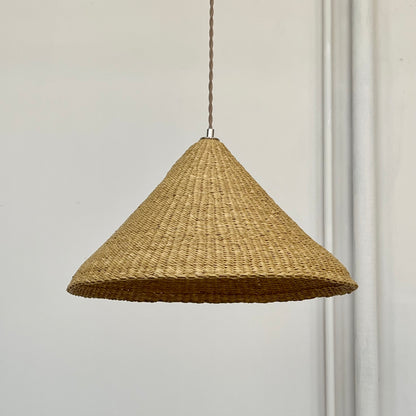 Our Bonnet pendant lights are a conical shape, handwoven from natural colored, indigenous elephant grass by members of a women’s organization in northern Ghana. A perfect-sized pendant for any room or living space.