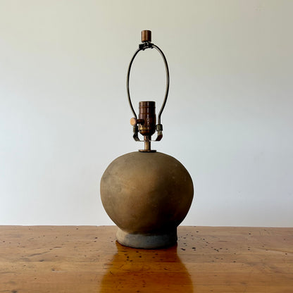 Shown here is the The Ash Lamp's handcrafted, round, terracotta colored ceramic base with it's light fixture.