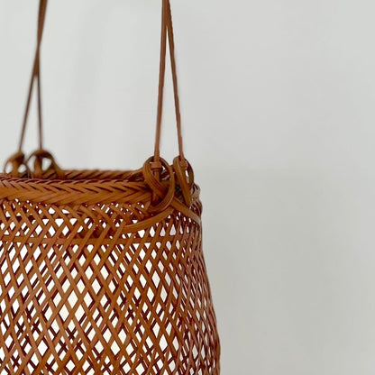 A small smoked bamboo basket handcrafted and hand woven by Japanese artist Mie Kodama.