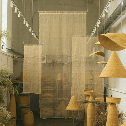 The Cortina Maguey is a handwoven sheer textile hanging. It's made in Oaxaca, Mexico, from the leftover maguey leaves from mezcal production. These natural colored curtains make beautiful room dividers, window coverings or wall hangings, and can be custom made to any size.