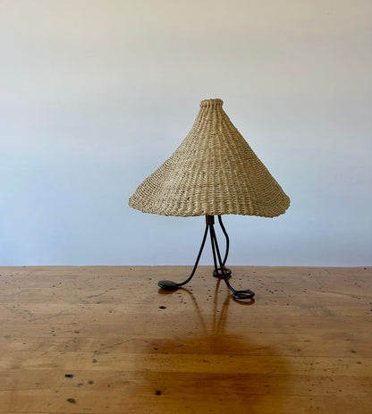 Modernist, iron table lamp from France circa 1950s. Paired with a coned shaped hand woven lamp shade.