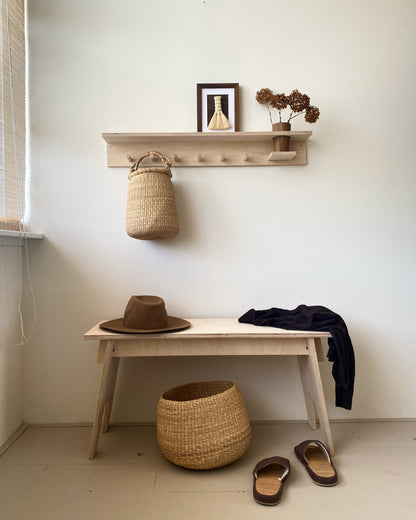 Hallway basket storage. Small handwoven baskets made from natural colored elephant grass, from northern Ghana.