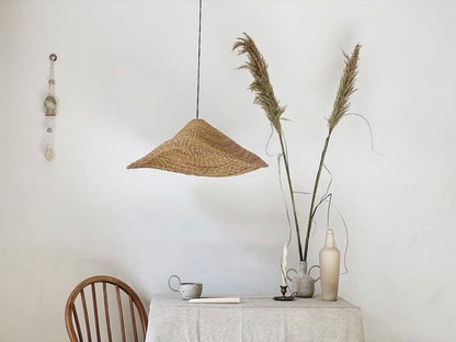 Woven light shade over a table. Natural colors.