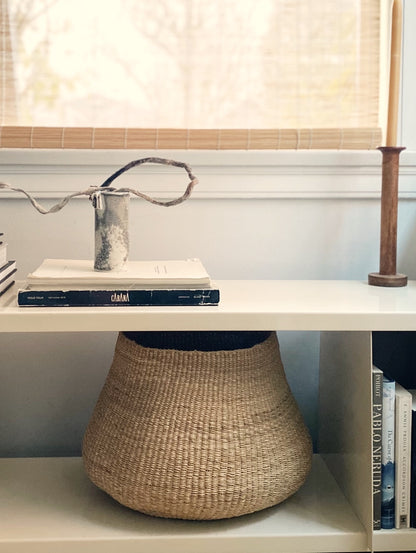 Small handwoven basket on a shelf,  made from natural colored elephant grass, Ghana.