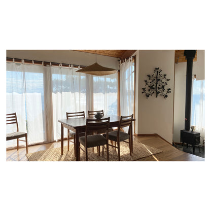 The Sunhat pendant light (shown here over a dining table with 4 chairs) is a shallow cone shape, handwoven from natural colored, sustainable elephant grass in northern Ghana. With its classic shape this pendant is ideal for any living space.