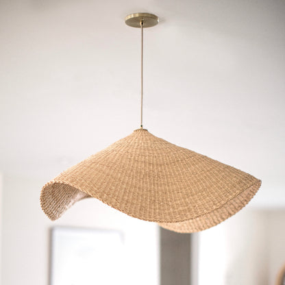 The Landslide pendant lights are made with natural colored, sustainable elephant grass in northern Ghana. Hand woven as a shallow cone and shaped into undulating waves, these lights are beautiful in bedrooms as well as living spaces.