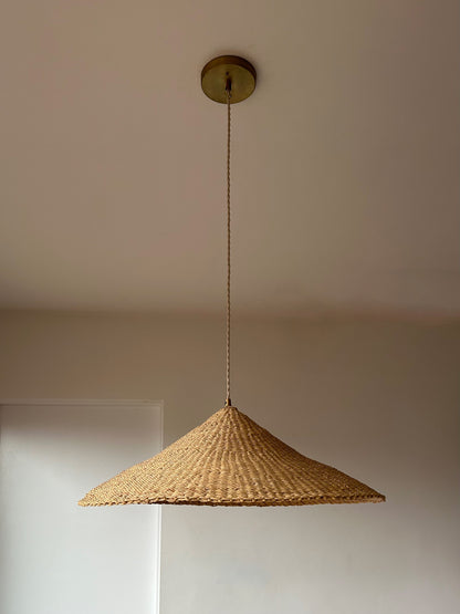 The Sunhat pendant light is a shallow cone shape, handwoven from natural colored, sustainable elephant grass in northern Ghana. With its classic shape this pendant is ideal for any living space.