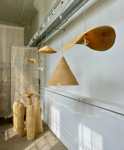 Our Fawn pendant lights are handwoven from natural colored elephant grass in northern Ghana.  Their wide and floating shape is striking in any living space, especially over a dining table or kitchen island.