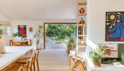 Beautiful living space with dining table, leading into a garden.