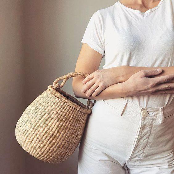 Woman carrying a handwoven basket with handle. Made in northern Ghana from natural colored elephant grass.