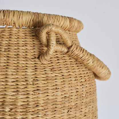 Close of of textural detail of hand woven basket with handle.