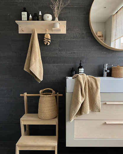 In a bathroom there's a small handwoven basket made from natural colored elephant grass, from northern Ghana.