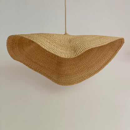 Fawn light shade handwoven from sustainable elephant grass in Ghana. Their wide and floating shape are striking in any living space, especially in bedrooms or over dining tables.