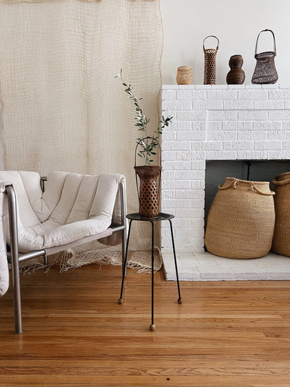 Many bamboo baskets, handcrafted and hand woven by Japanese artist Mie Kodama. Shown in a sitting room with a fire place.