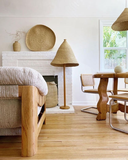 Over sized light shade on a floor lamp in a natural colored living room.